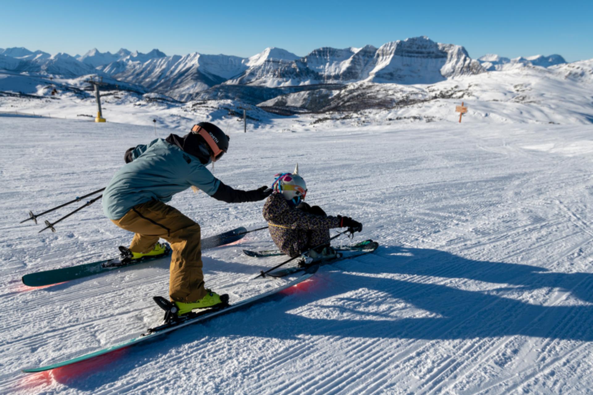 A mother skiing with her daughter at Banff Sunshine Village on a sunny winter day A mother skiing with her daughter at Banff Sunshine Village on a sunny winter day